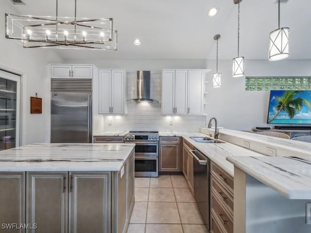 kitchen featuring sink, white cabinetry, stainless steel appliances, light stone countertops, and wall chimney exhaust hood