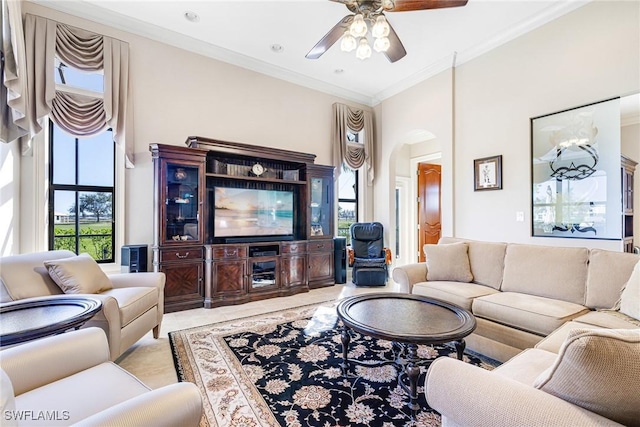 living room featuring crown molding, a towering ceiling, and ceiling fan