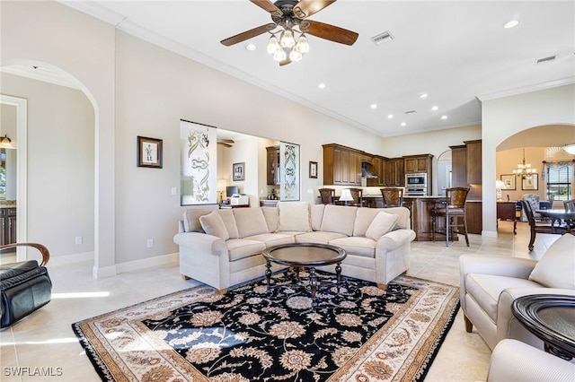 living room featuring ceiling fan with notable chandelier, ornamental molding, and light tile patterned floors