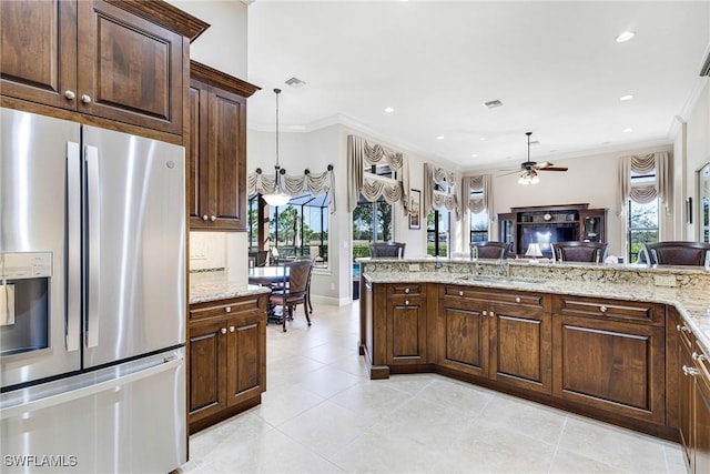 kitchen with decorative light fixtures, sink, stainless steel refrigerator with ice dispenser, and crown molding