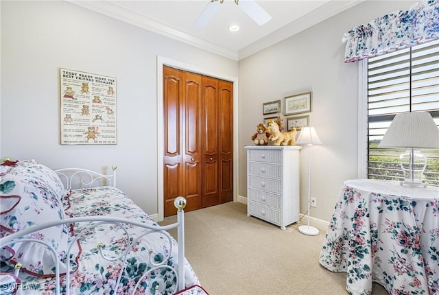 carpeted bedroom with a closet, ornamental molding, and ceiling fan