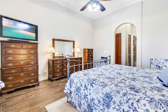 bedroom featuring hardwood / wood-style floors, ceiling fan, and crown molding