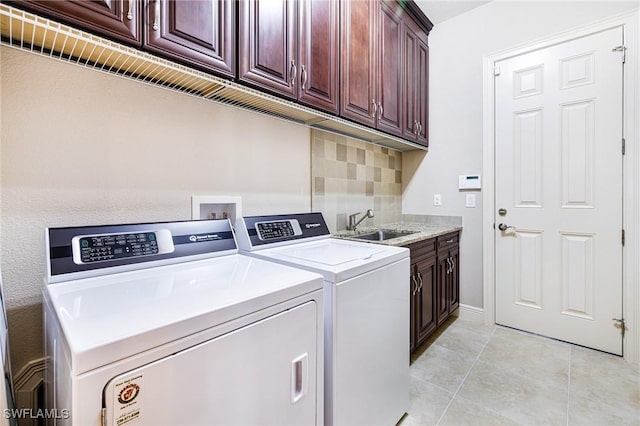 laundry area with cabinets, washing machine and dryer, sink, and light tile patterned flooring