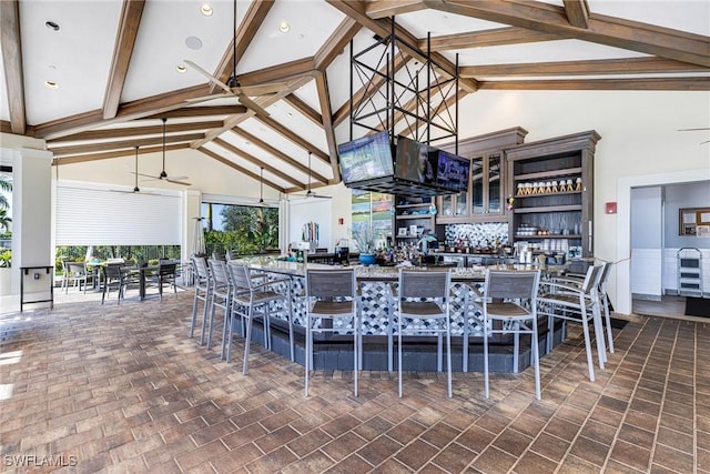 kitchen featuring beamed ceiling, ceiling fan, and high vaulted ceiling