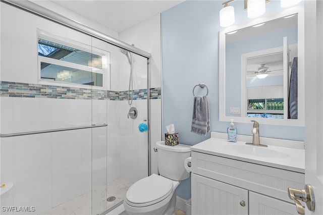 bathroom featuring ceiling fan, vanity, a shower with shower door, and toilet