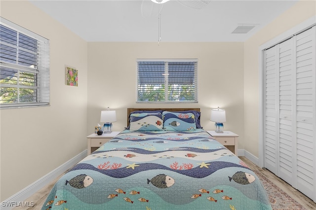 bedroom with hardwood / wood-style floors, a closet, and ceiling fan