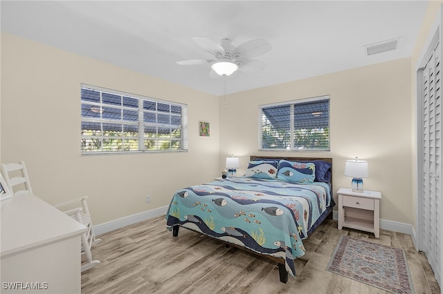 bedroom featuring ceiling fan, light wood-type flooring, and a closet