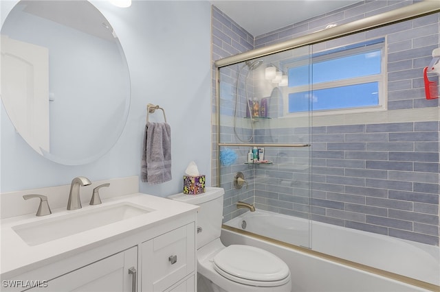 full bathroom featuring toilet, vanity, and combined bath / shower with glass door