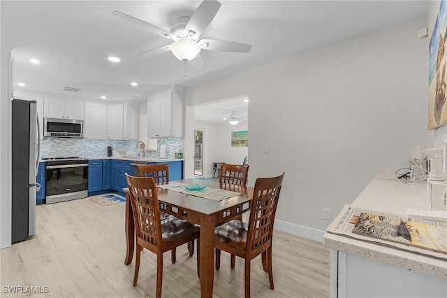 dining space with ceiling fan and light wood-type flooring