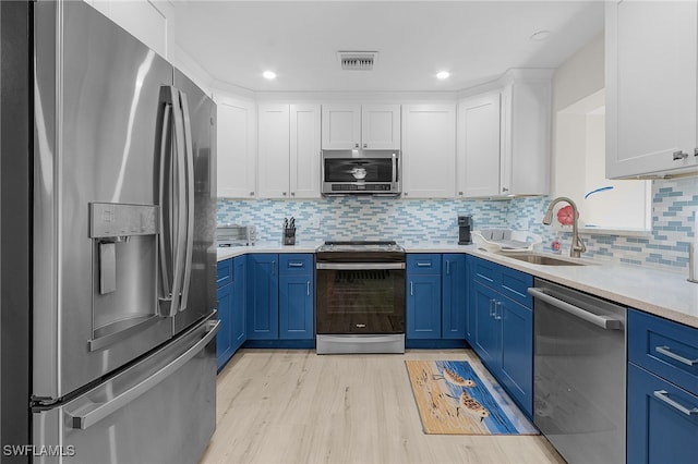 kitchen featuring white cabinets, stainless steel appliances, blue cabinets, and light hardwood / wood-style floors