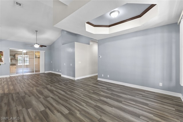 empty room featuring a raised ceiling, ceiling fan, dark hardwood / wood-style floors, and ornamental molding