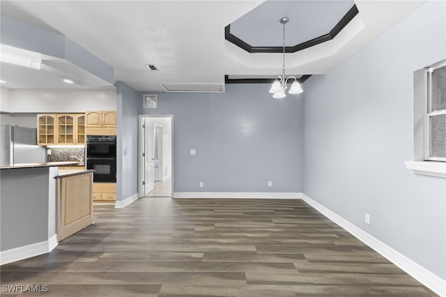 kitchen with light brown cabinets, backsplash, an inviting chandelier, stainless steel fridge, and double oven