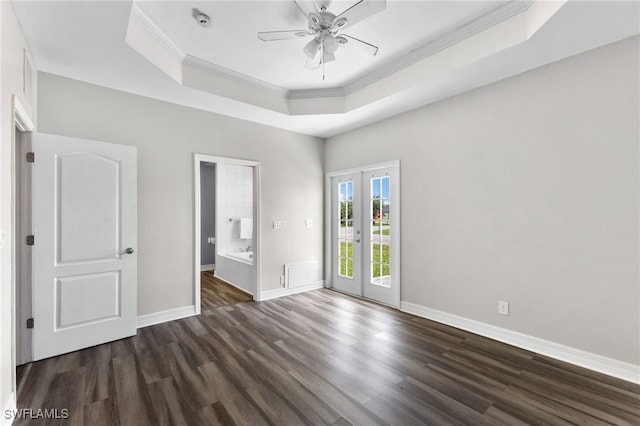 empty room with french doors, dark hardwood / wood-style flooring, ornamental molding, a raised ceiling, and ceiling fan