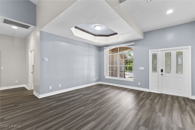 entrance foyer with a tray ceiling and dark wood-type flooring