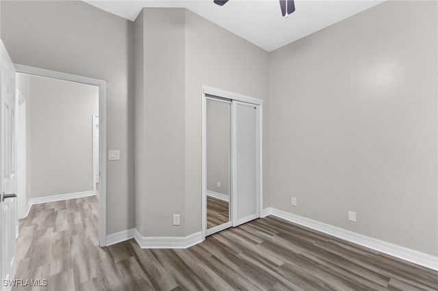 unfurnished bedroom with light wood-type flooring, a closet, and ceiling fan