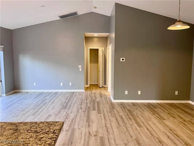 empty room with lofted ceiling and light wood-type flooring