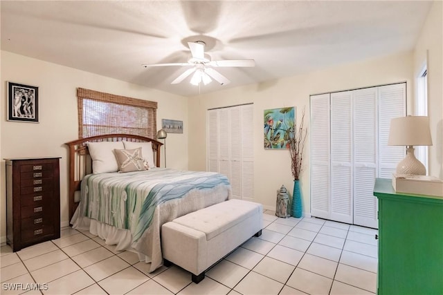 tiled bedroom with ceiling fan and multiple closets