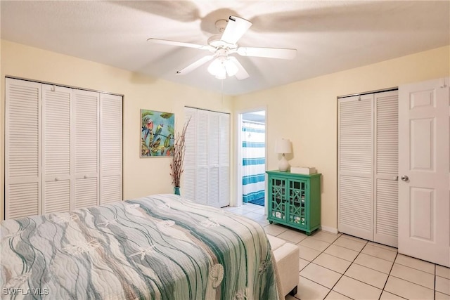 tiled bedroom featuring two closets and ceiling fan