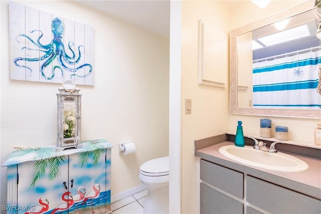 bathroom with tile patterned flooring, vanity, and toilet