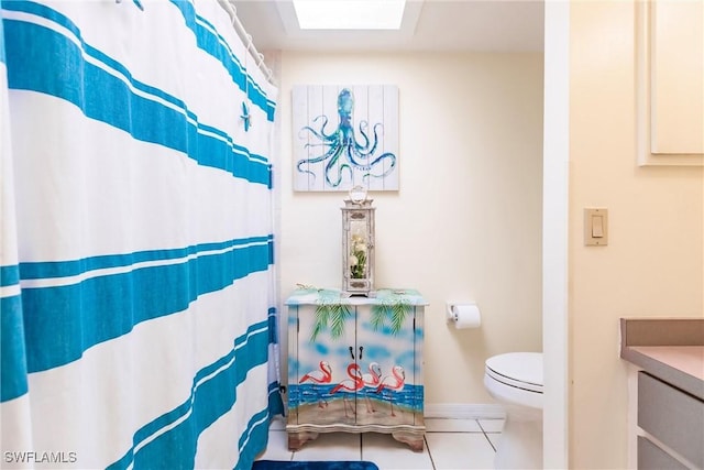 bathroom with tile patterned flooring, toilet, and a skylight