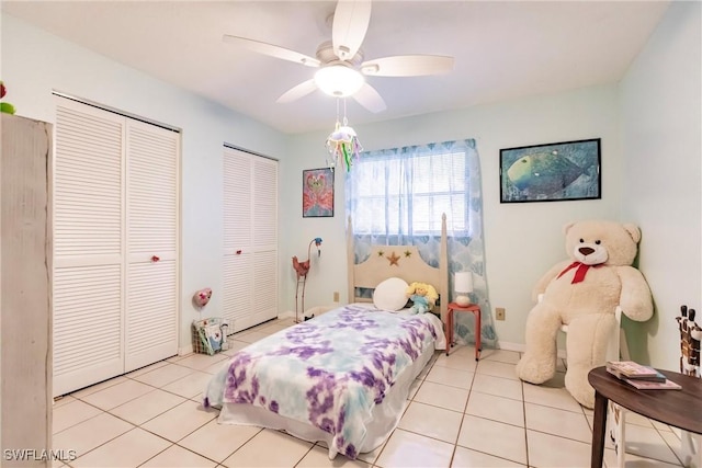 bedroom featuring multiple closets, ceiling fan, and light tile patterned floors