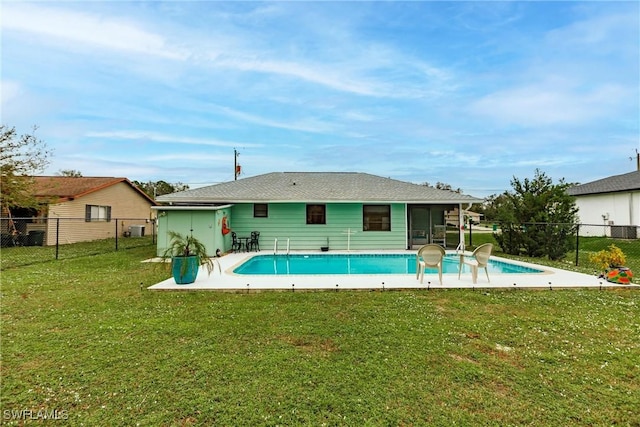 back of house with a fenced in pool and a yard