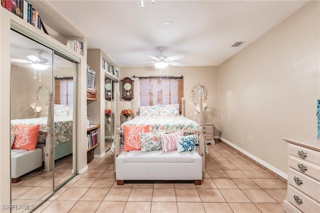 tiled bedroom with ceiling fan and a closet