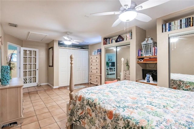 tiled bedroom with two closets and ceiling fan