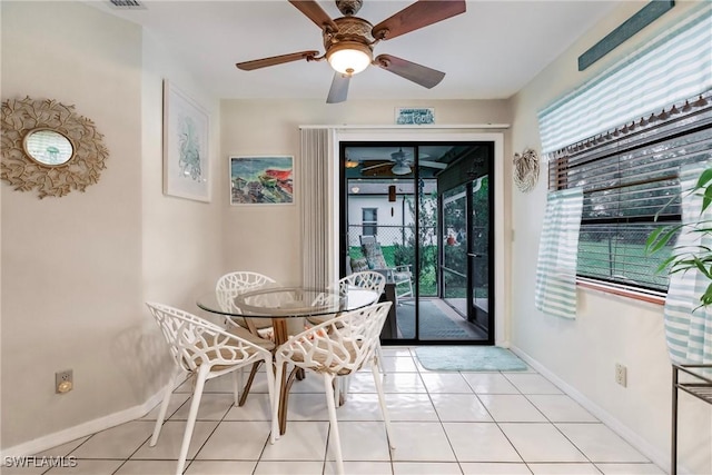 tiled dining area with plenty of natural light and ceiling fan