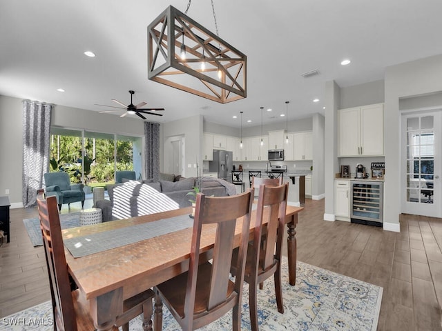 dining area featuring wine cooler, wood finished floors, visible vents, and recessed lighting