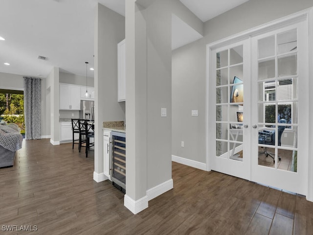 unfurnished dining area with french doors, wine cooler, dark wood-type flooring, and visible vents