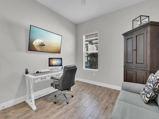 office space with light wood-type flooring and baseboards