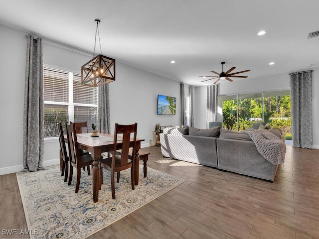 dining room with recessed lighting, visible vents, wood finished floors, baseboards, and ceiling fan with notable chandelier