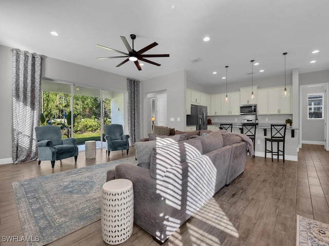 living area featuring light wood finished floors, baseboards, visible vents, and recessed lighting