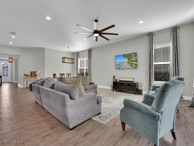 living area featuring recessed lighting, a ceiling fan, baseboards, visible vents, and light wood-style floors