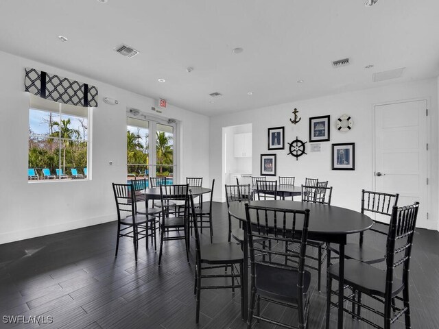 dining area with dark wood-style floors, visible vents, and baseboards