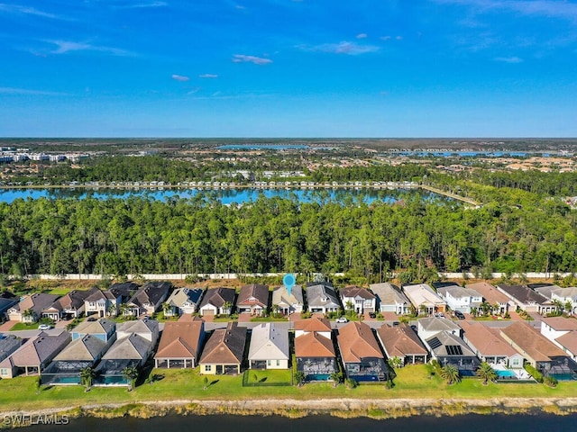 drone / aerial view featuring a water view, a residential view, and a view of trees