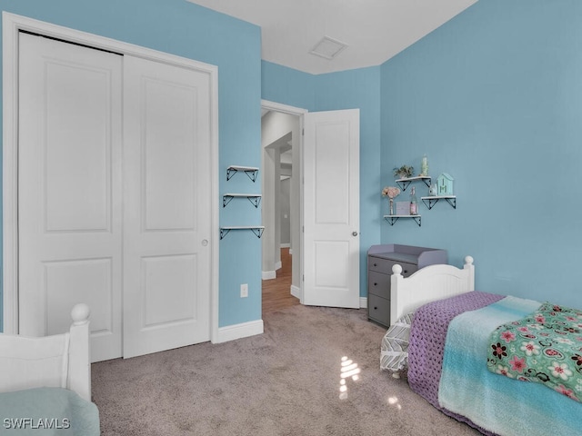 bedroom featuring visible vents, baseboards, a closet, and light colored carpet