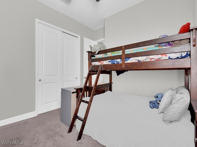 bedroom with a closet, carpet flooring, visible vents, and baseboards