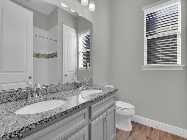 full bathroom featuring wood finished floors, a sink, toilet, and baseboards