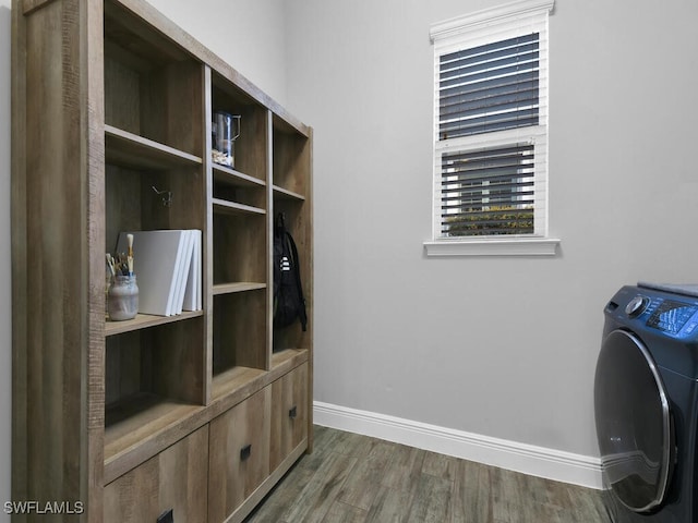 interior space featuring washer / dryer, baseboards, laundry area, and dark wood finished floors