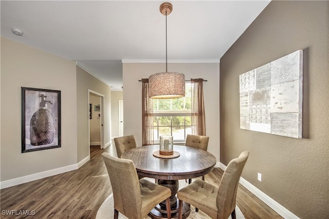 dining area featuring dark hardwood / wood-style flooring and ornamental molding