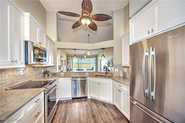 kitchen featuring stainless steel appliances, ceiling fan, sink, white cabinets, and hanging light fixtures