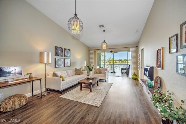 living room with ceiling fan, wood-type flooring, and vaulted ceiling