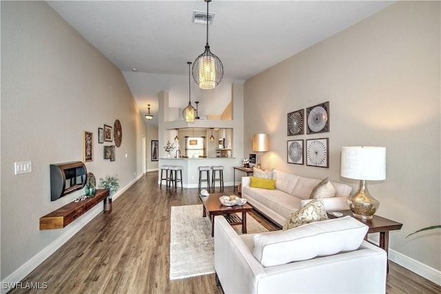 living room featuring dark hardwood / wood-style flooring and vaulted ceiling