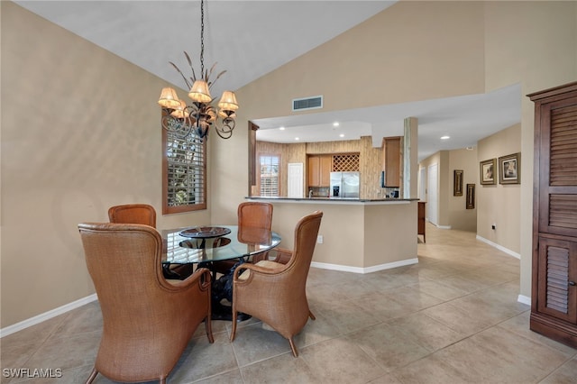 dining area with light tile patterned flooring, a chandelier, and vaulted ceiling