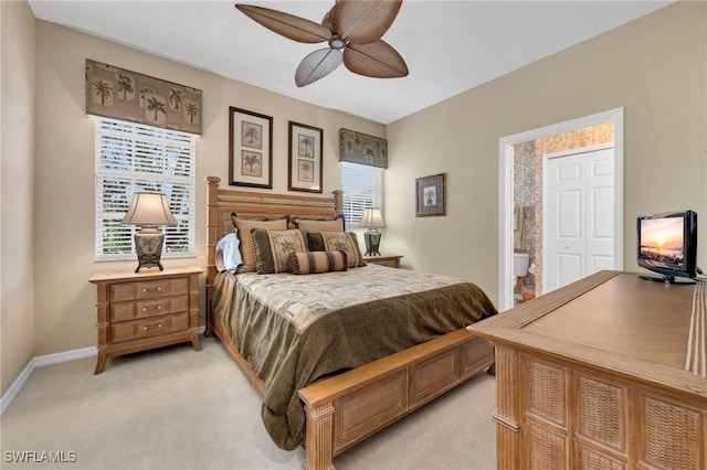 carpeted bedroom featuring a closet, ensuite bath, and ceiling fan