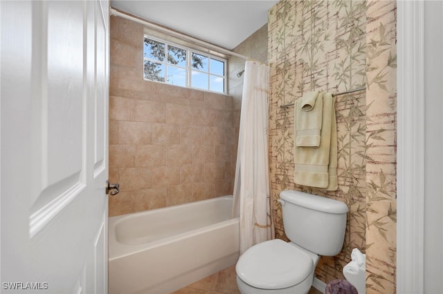 bathroom featuring tile patterned floors, shower / tub combo with curtain, and toilet