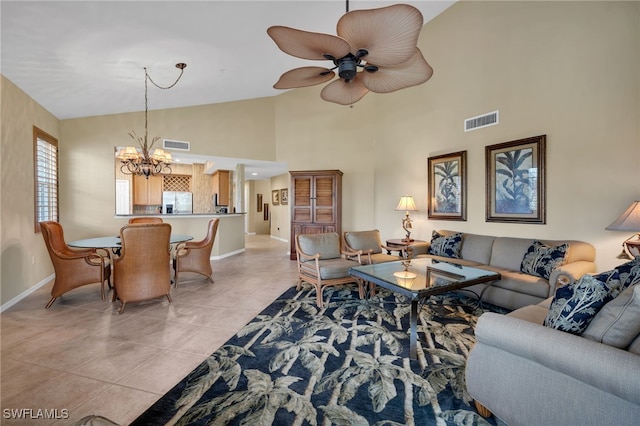 living room with ceiling fan with notable chandelier, light tile patterned flooring, and high vaulted ceiling