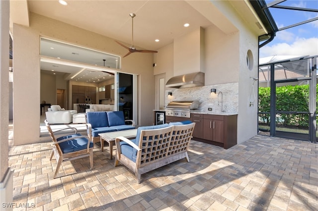 view of patio featuring grilling area, glass enclosure, ceiling fan, exterior kitchen, and outdoor lounge area